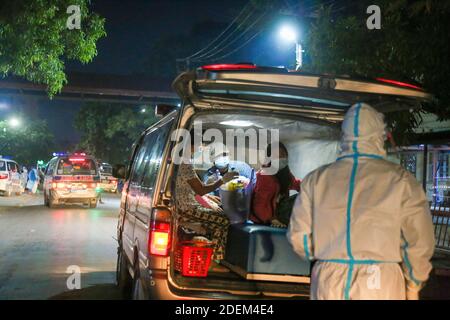 Mandalay, Myanmar. 24 Nov 2020. Un volontario che indossa attrezzatura protettiva trasporta i pazienti positivi di Covid-19 dal General Hospital di Mandalay al centro positivo di Covid-19.Charitable Minkhaung Search and Rescue Team a Obo Ward, a nord di Mandalay è un'organizzazione caritativa che trasporta principalmente i pazienti confermati di Covid-19. Tutti i membri di questa organizzazione dovevano rimanere in ufficio invece di tornare a casa perché i loro genitori e dintorni non potevano accettarli perché trasportavano i pazienti confermati dal Covid-19. Il caritatevole Minkhaung Search and Rescue Team ha tr Foto Stock