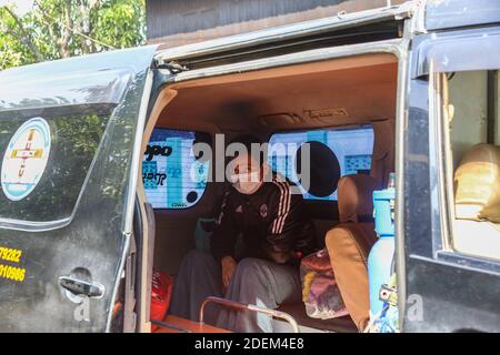 Mandalay, Myanmar. 24 Nov 2020. Un paziente positivo Covid-19 si trova in un ambulance.Charitable Minkhaung Search and Rescue Team a Obo Ward, Nord di Mandalay è un'organizzazione caritativa che trasporta principalmente pazienti confermati Covid-19. Tutti i membri di questa organizzazione dovevano rimanere in ufficio invece di tornare a casa perché i loro genitori e dintorni non potevano accettarli perché trasportavano i pazienti confermati dal Covid-19. Il caritatevole Minkhaung Search and Rescue Team ha trasformato una media di quasi (5000) Covid-19 pazienti confermati e l'associazione al Foto Stock