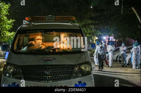 Mandalay, Myanmar. 24 Nov 2020. Un volontario che indossa attrezzatura protettiva trasporta i pazienti positivi di Covid-19 dal General Hospital di Mandalay al centro positivo di Covid-19.Charitable Minkhaung Search and Rescue Team a Obo Ward, a nord di Mandalay è un'organizzazione caritativa che trasporta principalmente i pazienti confermati di Covid-19. Tutti i membri di questa organizzazione dovevano rimanere in ufficio invece di tornare a casa perché i loro genitori e dintorni non potevano accettarli perché trasportavano i pazienti confermati dal Covid-19. Il caritatevole Minkhaung Search and Rescue Team ha tr Foto Stock