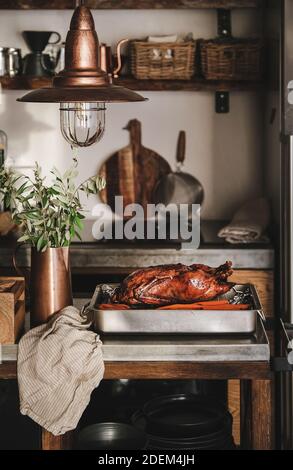Anatra arrosto forno intero per la festa del Ringraziamento o festa di Natale in vassoio di metallo sopra gli interni della cucina moderna. Tradizionale concetto di cibo per le vacanze autunnali o invernali Foto Stock