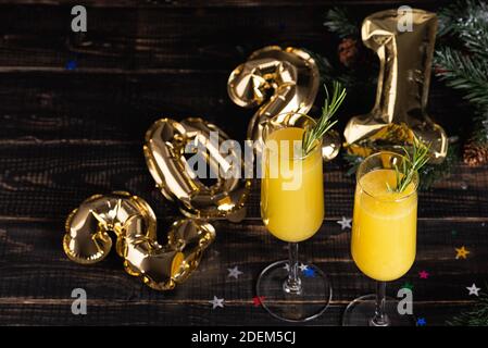 Cocktail Mimosa con succo d'arancia e champagne. Festa di Capodanno 2021 con una discoteca a specchio palle. Video verticale Foto Stock
