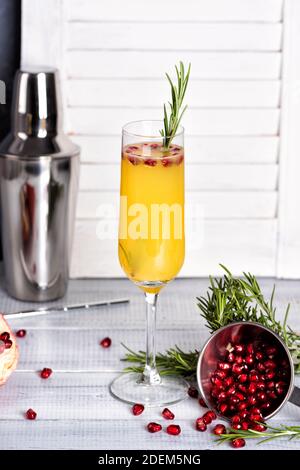Cocktail Mimosa con succo d'arancia e champagne. Festa di Capodanno o di compleanno. Melograno e rosmarino Foto Stock