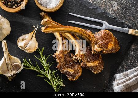 Costolette di agnello grigliate su tagliere di pietra. Vista dall'alto. Foto Stock