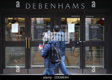 Le persone che passeranno oltre i grandi magazzini Debenhams sulla High Street a Winchester, Hampshire, la catena di grandi magazzini di 242 anni ha dichiarato che i suoi amministratori hanno purtroppo deciso di avviare il processo di liquidazione, continuando a cercare offerte. Foto Stock