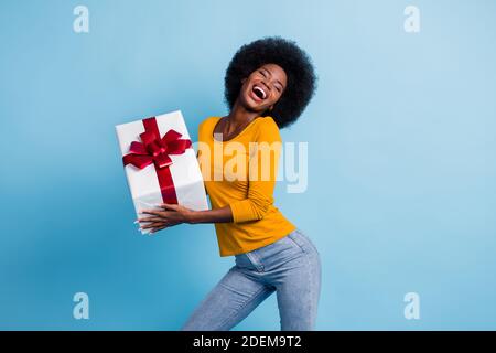 Ritratto fotografico di felice sorridente donna nera con pelle che si avvolge dono ridere ballando isolato su sfondo di colore blu brillante Foto Stock