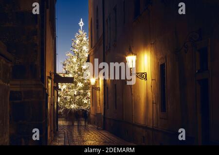 Vacanze di Natale in città. Strada stretta Città Vecchia contro illuminato albero di Natale. Praga, Repubblica Ceca Foto Stock