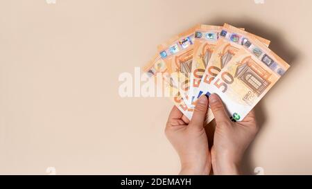 Un uomo ha in mano un sacco di 50 banconote in euro. Un banner con una posizione per il testo. Foto Stock