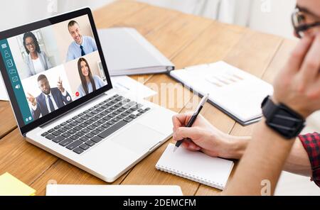Uomo che ha una videoconferenza con il team mentre lavora da casa Foto Stock