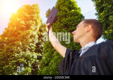 Il ragazzo laureato di successo, in abiti accademici, cappellino di laurea rialzato, scuola di Arrivederci , può essere utilizzato per la pubblicità, Foto Stock