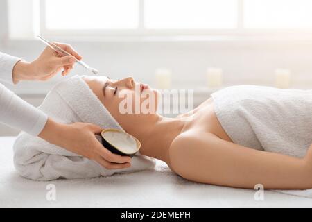 Giovane donna bella con trattamento viso presso spa Foto Stock