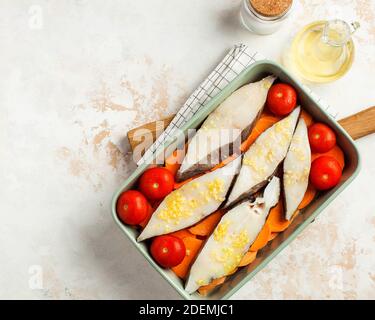 Bistecche di halibut ghiacciate in un piatto da forno con pomodori e patate dolci. Spazio di copia. Piatto di pesce. Foto Stock