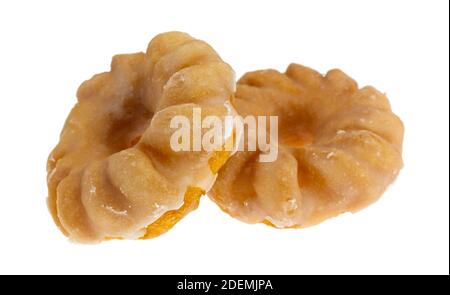 Vista laterale di due cruller a morso smaltati su sfondo bianco. Foto Stock