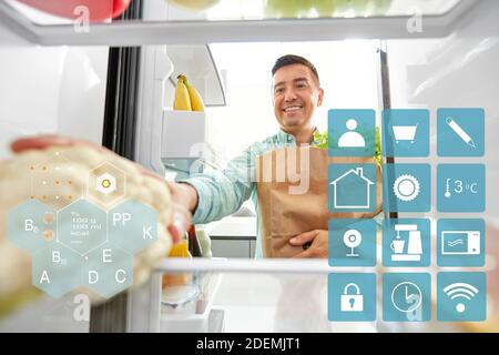 L'uomo ponendo nuove acquistate alimenti home frigo Foto Stock