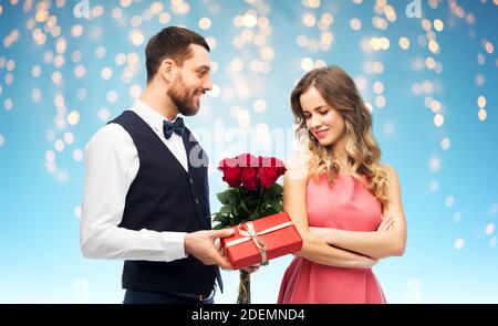 Felice l'uomo che donna fiori e presente Foto Stock