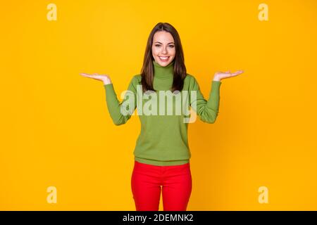 Ritratto di bella ragazza allegra tenendo su due palme copia lo spazio offre isolamento su uno sfondo di colore giallo brillante Foto Stock