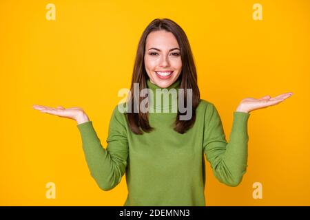 Ritratto di ragazza allegra attraente che tiene sulla copia delle palme decisione spaziale isolata su sfondo giallo brillante Foto Stock