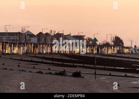 Sole che illumina la fila di capanne da spiaggia all'alba, alba il primo giorno di inverno meteorologico, 2020 dicembre a Southend on Sea, Essex, Regno Unito. Fila di capanne Foto Stock