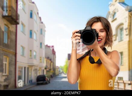 felice fotografo donna con macchina fotografica in città Foto Stock