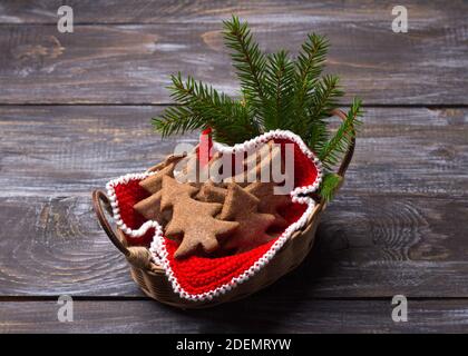 Biscotti al pan di zenzero di avena a forma di albero di Natale in un cestino su un tavolo di legno, stile rustico, fuoco selettivo Foto Stock