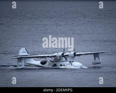 Temple Pier, Loch Ness, Highland, Scozia, 1 dicembre 2020. Catalina, "Miss Pick Up", si prepara per il decollo dopo essere stato abbassato nuovamente in acqua con una gru in preparazione per il suo volo di ritorno a Duxford via Inverness. L'idrovolante ha funzionato nei problemi di motore sabato 17 ottobre ed è rimasto al molo del tempio vicino Drumnadrochit fino a che un motore di tribordo di sostituzione non potesse essere montato e provato. Idrovolante consolidato PBY-5A Catalina "Miss Pick Up" 433915/G-PBYA. Foto Stock