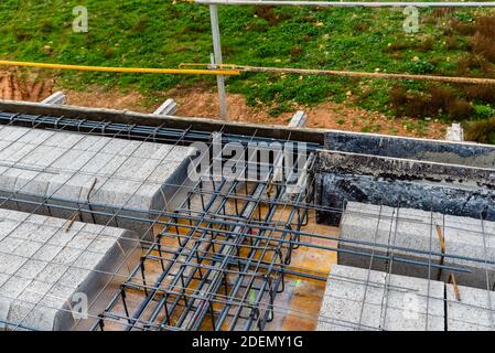 Cantiere con casseri in acciaio e barre di rinforzo per pilastri pronto per la colata di calcestruzzo Foto Stock