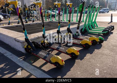 BUCAREST, ROMANIA - 26 novembre 2020: Scooter splash e bulloni in affitto foderato in città in attesa di essere affittato tramite telefono app Foto Stock