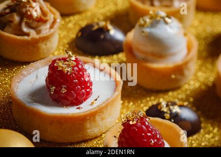 Primo piano sulle crostate di lampone e meringa di limone con piccoli bocconcini di cioccolato Foto Stock