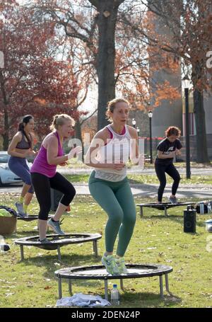 Donne in una classe Urban Rebounding ballando mentre su un trampolino piccolo. Nel Flushing Meadows Corona Park a Queens, New York City. Foto Stock