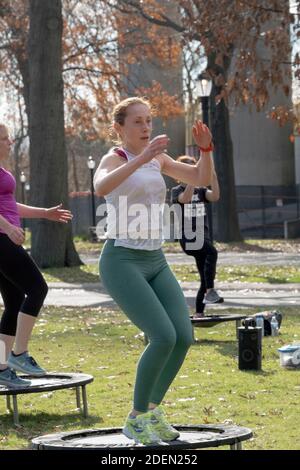 Donne in una classe Urban Rebounding ballando mentre su un trampolino piccolo. Nel Flushing Meadows Corona Park a Queens, New York City. Foto Stock