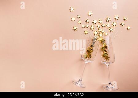 Bicchieri di champagne con spruzzi dorati scintillanti su sfondo rosa. Disposizione piatta, vista dall'alto, stile natalizio alla moda. Foto Stock