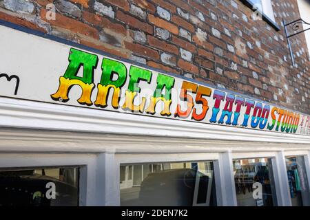 Cartello con il nome sopra Area 55 Tattoo Studio in East Street, Blandford Forum, una città mercato in Dorset, Inghilterra sud-occidentale, con tipica architettura georgiana Foto Stock