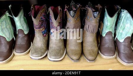 Colorati stivali da cowboy sul ripiano per scarpe alla moda Foto Stock