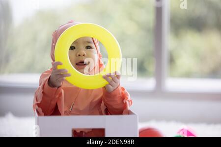 Muslim Baby gioca con giocattoli colorati nel soggiorno Foto Stock