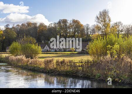 Autunno nel Cotswolds - il fiume Coln, rack Isle e Arlington Row nel villaggio di Bibury, Gloucestershire UK Foto Stock