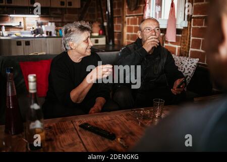 Marito anziano e moglie bevono insieme una rakija, una bevanda alcolica serba. Foto Stock