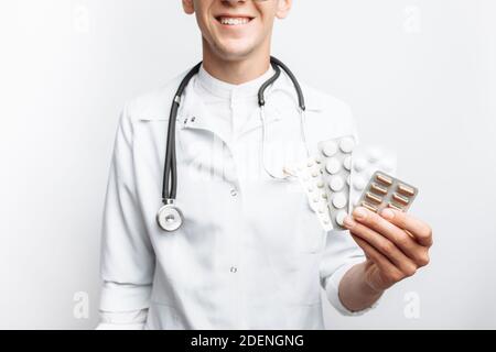 Medico di mano che tiene la compressa, primo piano, sfondo bianco, per la pubblicità Foto Stock