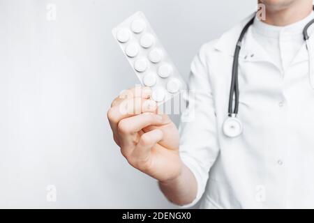 Medico di mano che tiene la compressa, primo piano, sfondo bianco, per la pubblicità Foto Stock