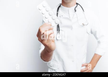 Medico di mano che tiene la compressa, primo piano, sfondo bianco, per la pubblicità Foto Stock