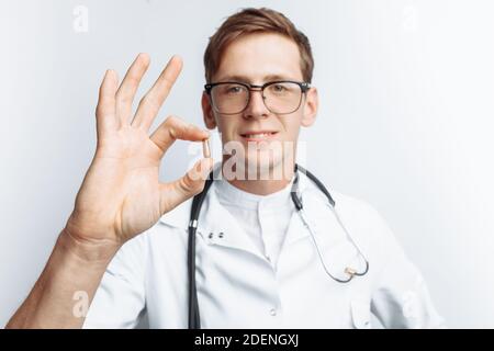 Medico di mano che tiene la compressa, primo piano, sfondo bianco, per la pubblicità Foto Stock