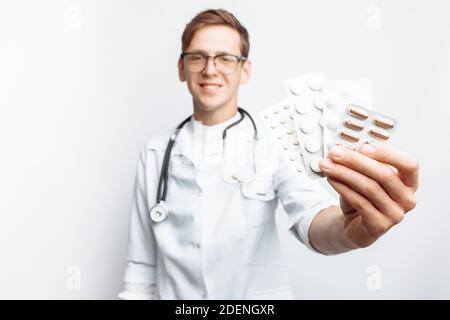 Medico di mano che tiene la compressa, primo piano, sfondo bianco, per la pubblicità Foto Stock
