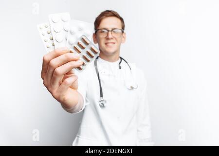 Medico di mano che tiene la compressa, primo piano, sfondo bianco, per la pubblicità Foto Stock
