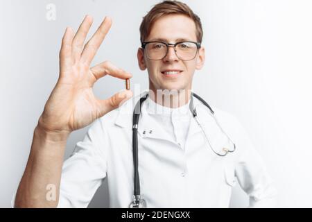Medico di mano che tiene la compressa, primo piano, sfondo bianco, per la pubblicità Foto Stock