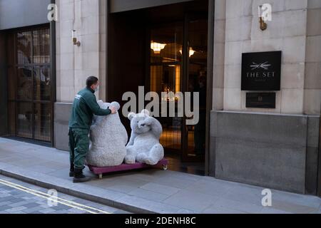 Due orsacchiotti di decorazione natalizia sono scaricati da un camion di subappaltatore e consegnati al foyer del Cafe Royal in Air Street, il 1 dicembre 2020, a Londra, Inghilterra. Gli orsi sono stati prodotti dalla società rumena Eugeniu Dumneanu Art-Grass, un fornitore di erba sintetica e erba sintetica specializzata nella copertura di superfici e instillazioni con erba artificiale e Astroturf. (Foto di Richard Baker / in immagini via Getty Images) Foto Stock