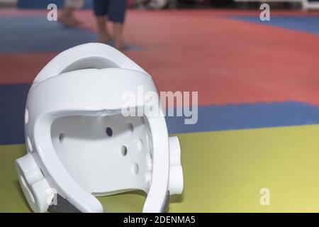 Sicurezza casco boxing e allenamento arti marziali. Vista frontale del casco con sfondo della sala di allenamento Foto Stock