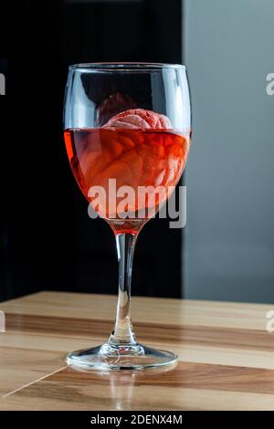 Cervello umano nel vino rosso di imbibizione di vetro per alcolismo tossicodipendenze concept Foto Stock