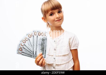 Bambina che tiene i soldi dollari nelle sue mani, sfondo bianco nello studio, Foto Stock