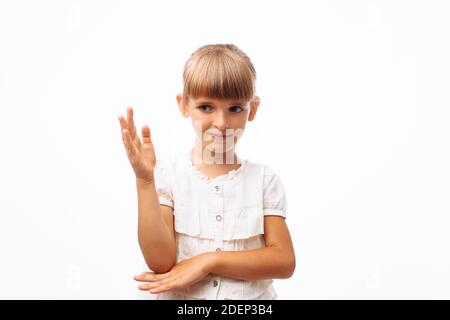 Bambina tenendo la mano per rispondere o fare una domanda, su sfondo bianco in Studio Foto Stock