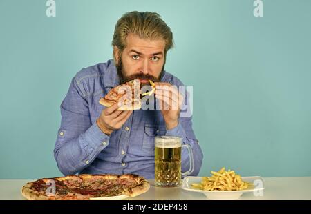 Grazie. Guardando il calcio in TV. fast food americano. Uomo con birra e pizza felice. Cibo italiano. Patatine fritte. Ragazzo al bar che beve bicchiere di birra Foto Stock