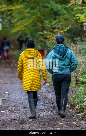 una coppia di mezza età che cammina insieme nella campagna indossando abiti da esterni dai colori vivaci. Foto Stock
