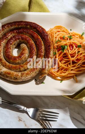 Salsiccia a spirale italiana cotta con spaghetti al pomodoro rosso salsa Foto Stock